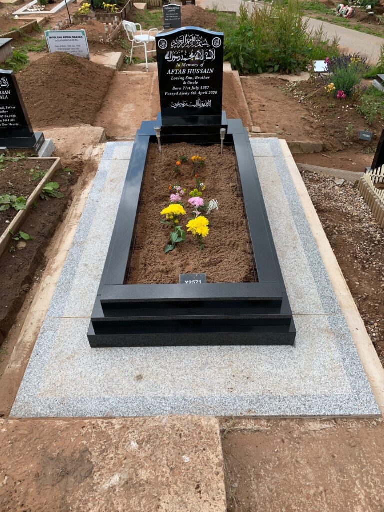 Black Standard Headstone With Two Stepped Kerbs And A Black Granite Frame Landing. With Concrete And Tiling
