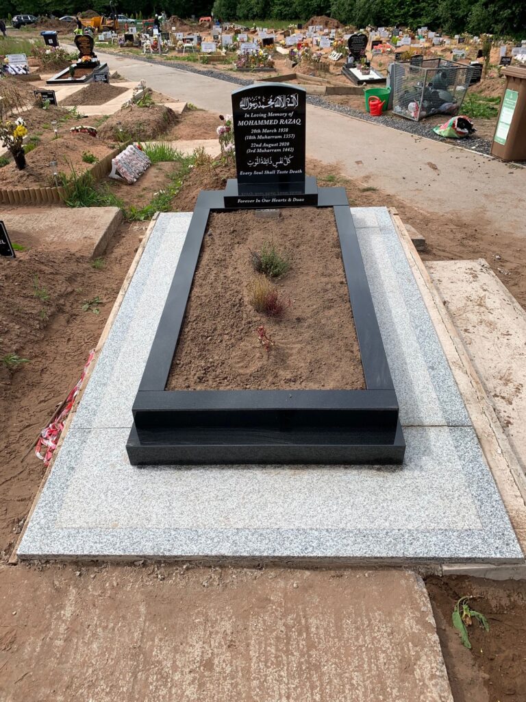 Medium Black Camber Headstone With Kerbs And A Black Granite Frame Landing. With Concrete And Tiling